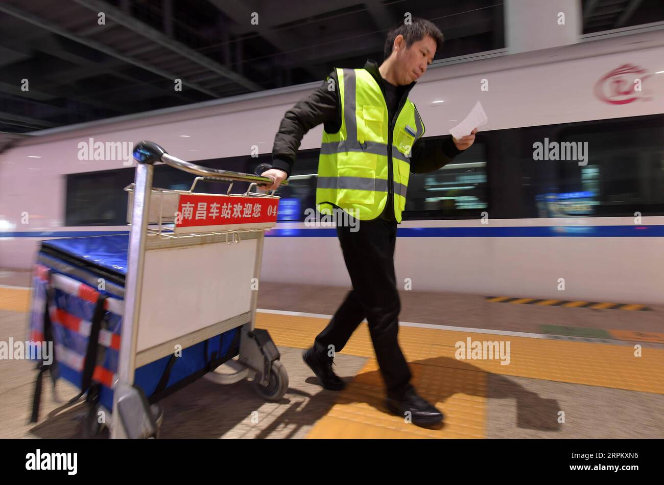 200120 -- NANCHANG, 20 gennaio 2020 -- Deliveryman ma Tao invia il pasto ordinato dai passeggeri al binario della stazione ferroviaria di Nanchang West a Nanchang, capitale della provincia del Jiangxi della Cina orientale, 18 gennaio 2020. Ma Tao, 45 anni, è un distributore di servizi di consegna di cibo su richiesta per i treni ad alta velocità. Durante la corsa al Festival di Primavera, ma viaggia da e verso il centro di distribuzione di cibo e le piattaforme per consegnare pasti caldi ai passeggeri a bordo del treno. In qualità di fattorino del cibo, ma Tao deve agire rapidamente e con precisione. Deve tenere il numero dei treni e dei trasporti dei clienti in min Foto Stock