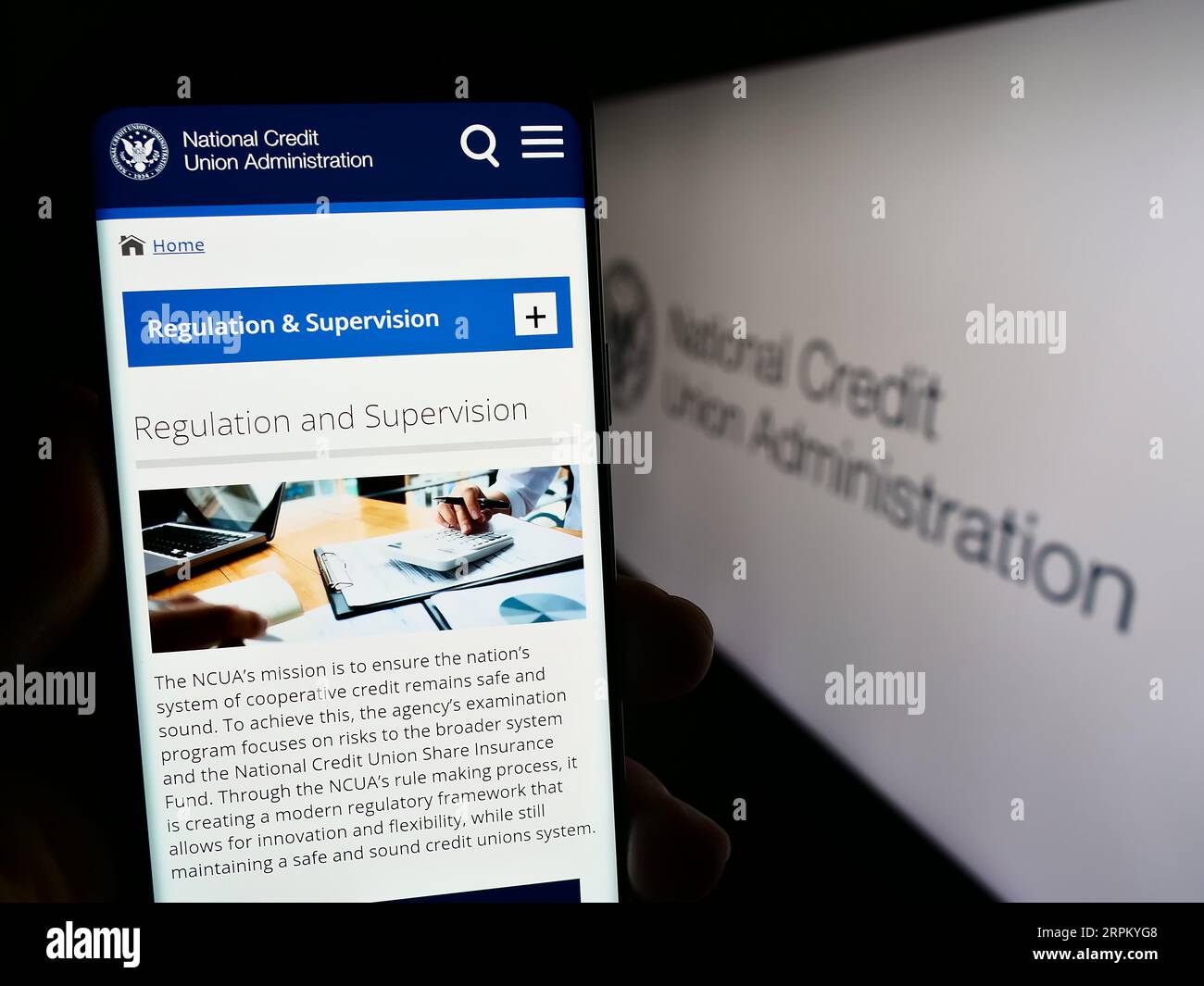 Persona che possiede uno smartphone con una pagina web dell'amministrazione nazionale del credito (NCUA) sullo schermo con sigillo. Concentrarsi sul centro del display del telefono. Foto Stock