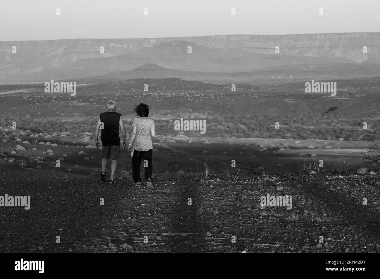 La coppia guarda il tramonto nel deserto del Namib in Namibia Foto Stock
