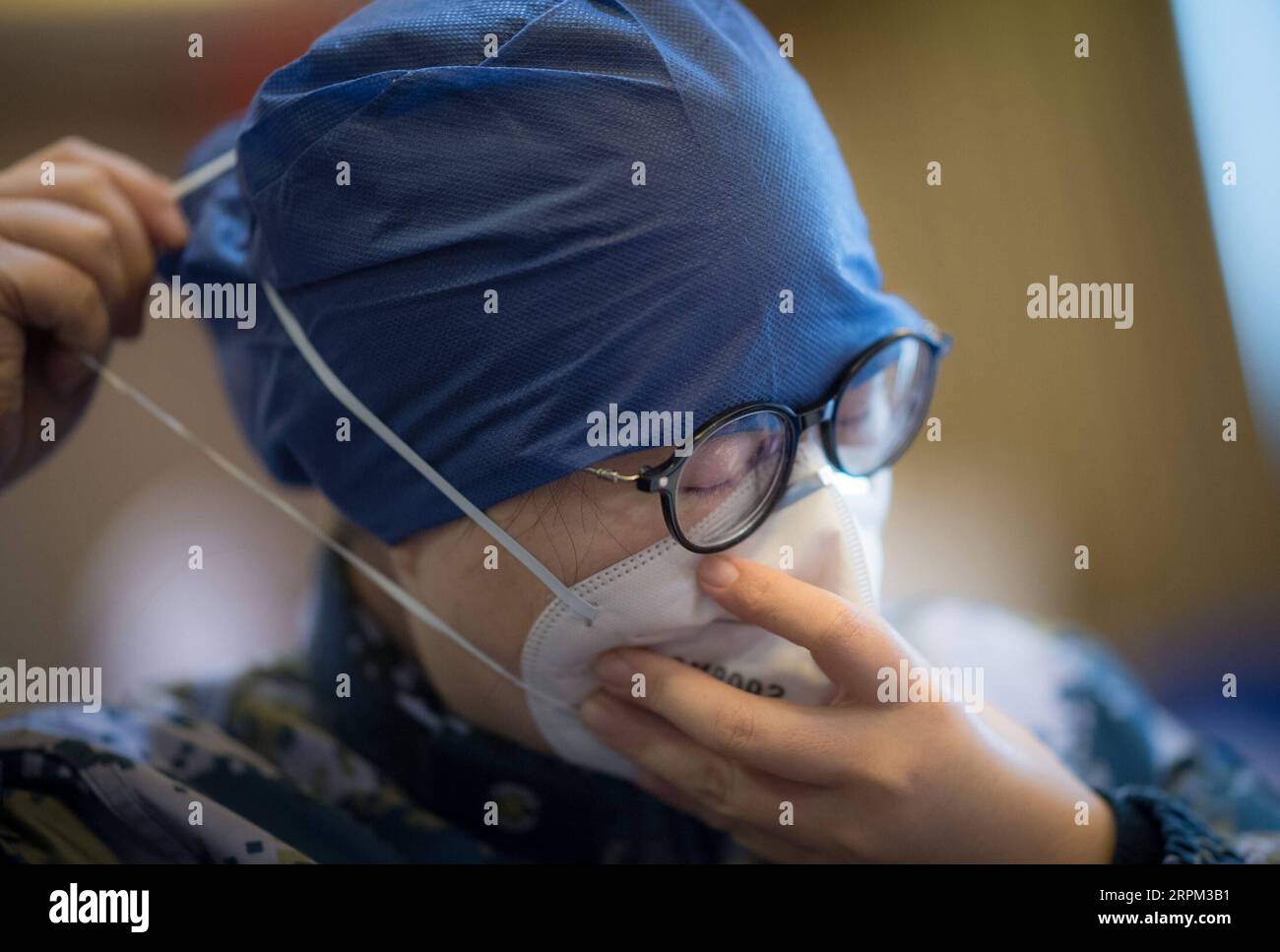200127 -- WUHAN, 27 gennaio 2020 -- Un membro della squadra medica della seconda Università medica militare indossa una maschera facciale all'ospedale Hankou di Wuhan, provincia di Hubei, Cina centrale, 27 gennaio 2020. L'equipe medica della seconda Università medica militare aiuta Hankou Hospital su problemi riguardanti la capacità dell'ospedale e la grave carenza di personale medico. L'equipe medica prevede di allestire reparti respiratori e due reparti da 78 posti letto presso l'ospedale Hankou. CHINA-WUHAN-CORONAVIRUS-MEDICAL TEAM-SUPPORT CN XIAOXYIJIU PUBLICATIONXNOTXINXCHN Foto Stock