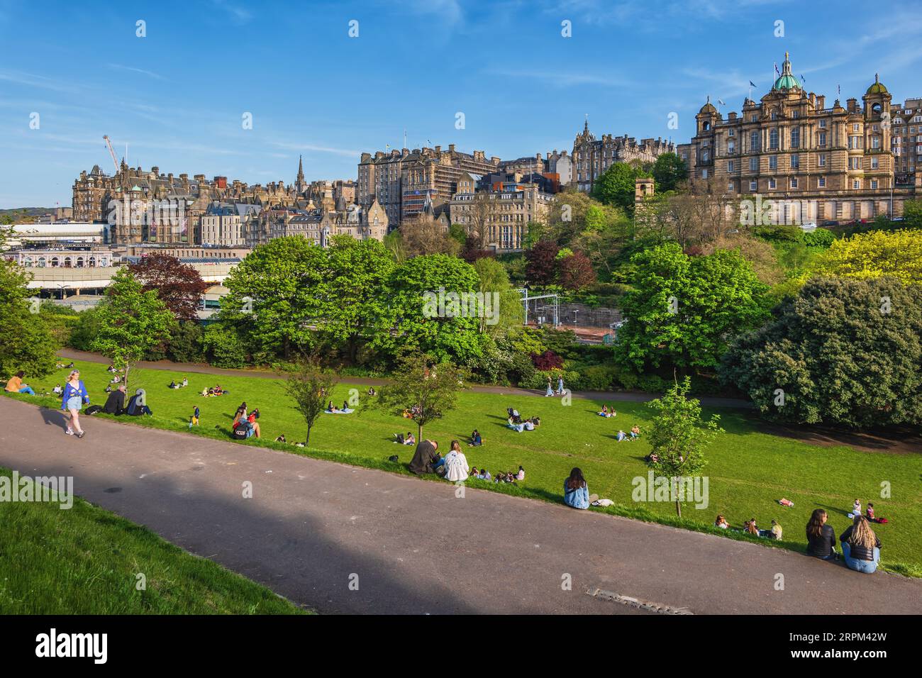 Edimburgo, Scozia, Regno Unito - 13 maggio 2023 - le persone si rilassano sul prato nei Princes Street Gardens, nel centro della città in primavera, sotto la città vecchia. Foto Stock