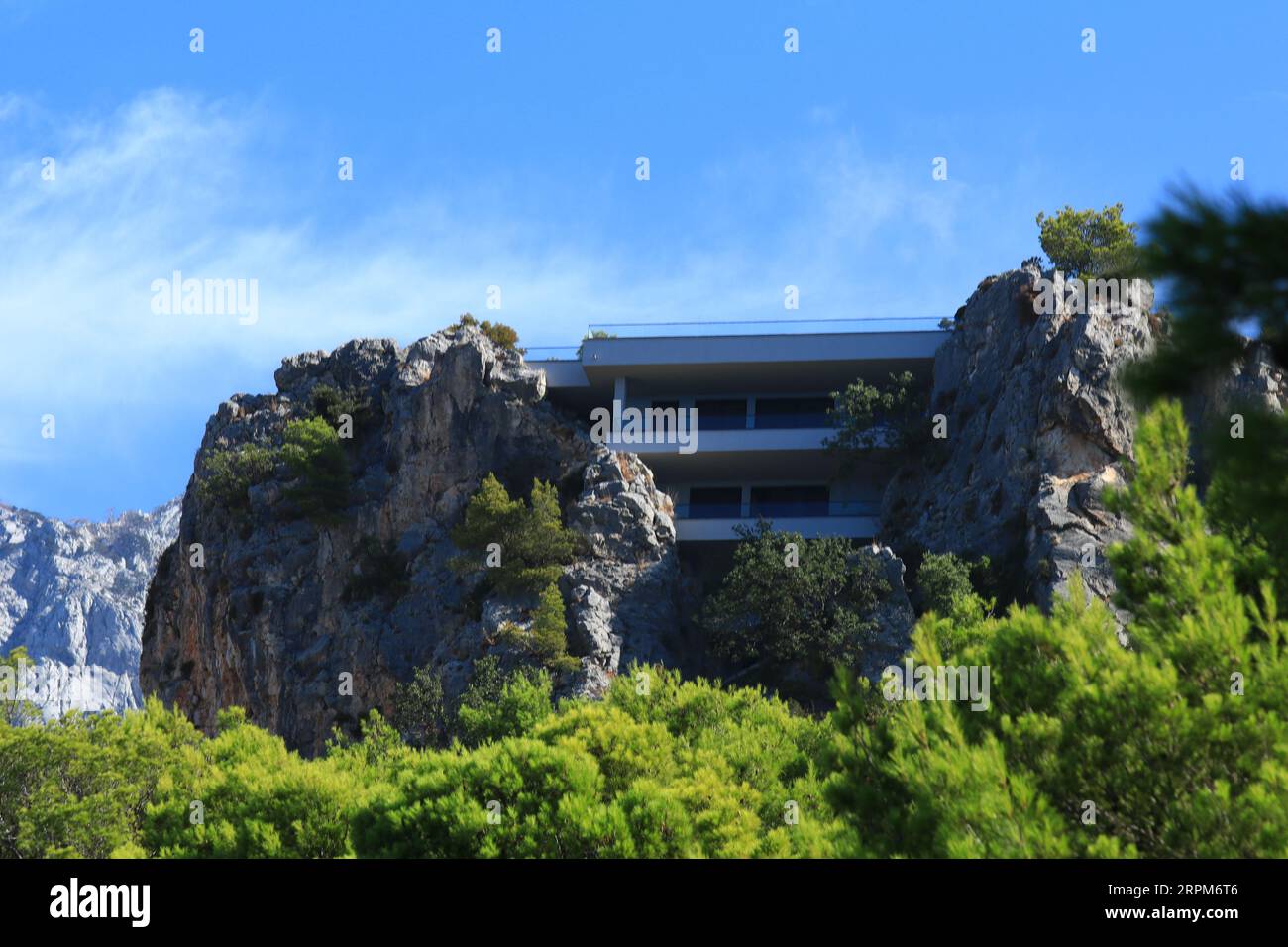 Una casa costruita su una roccia tra gli alberi Foto Stock