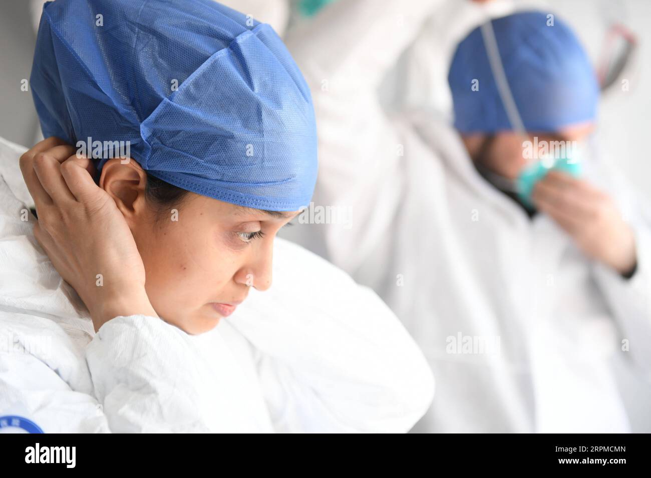 200208 -- WENZHOU, 8 febbraio 2020 -- Mauritian Hosany Sumayyah L e suo marito pakistano Abdul Zahir Hamad indossano tute protettive prima di mettersi al lavoro in un nuovo posto di controllo e prevenzione del coronavirus di un'uscita autostradale a Wenzhou, nella provincia dello Zhejiang della Cina orientale, 8 febbraio 2020. Abdul Zahir Hamad e Mauritian Hosany Sumayyah, una coppia sposata, lavorano entrambi come medici al Panhealth Medical Center di Wenzhou. Fin dallo scoppio del nuovo coronavirus, sono stati volontari in un checkpoint di uscita dell'autostrada a Wenzhou, controllando le informazioni sull'identità e misurando l'organismo Foto Stock