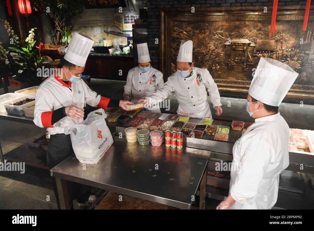 200215 -- CHONGQING, 15 febbraio 2020 -- i membri del personale di un ristorante di hot pot preparano cibo da asporto nel comune di Chongqing della Cina sud-occidentale, 15 febbraio 2020. Per la prevenzione e il controllo della nuova polmonite da coronavirus, alcuni ristoranti di pentole calde a Chongqing, sotto la guida della Commissione per il commercio municipale di Chongqing e dei servizi competenti, forniscono ai consumatori un servizio di asporto di pentole calde a contatto zero. I consumatori possono ordinare cibo attraverso varie piattaforme come il telefono, WeChat e Internet. I servizi di prelievo sono stati rafforzati in termini di sicurezza di acquisto, lavorazione e consegna, winnin Foto Stock