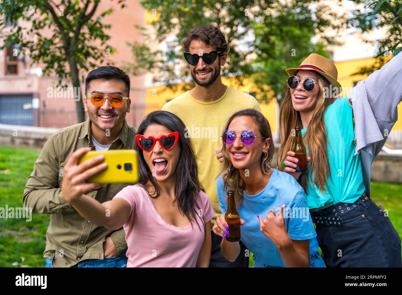 Gruppo multietnico di amici che festeggiano nel parco cittadino scattando un selfie, un concetto di amicizia e divertimento con gli occhiali da sole Foto Stock