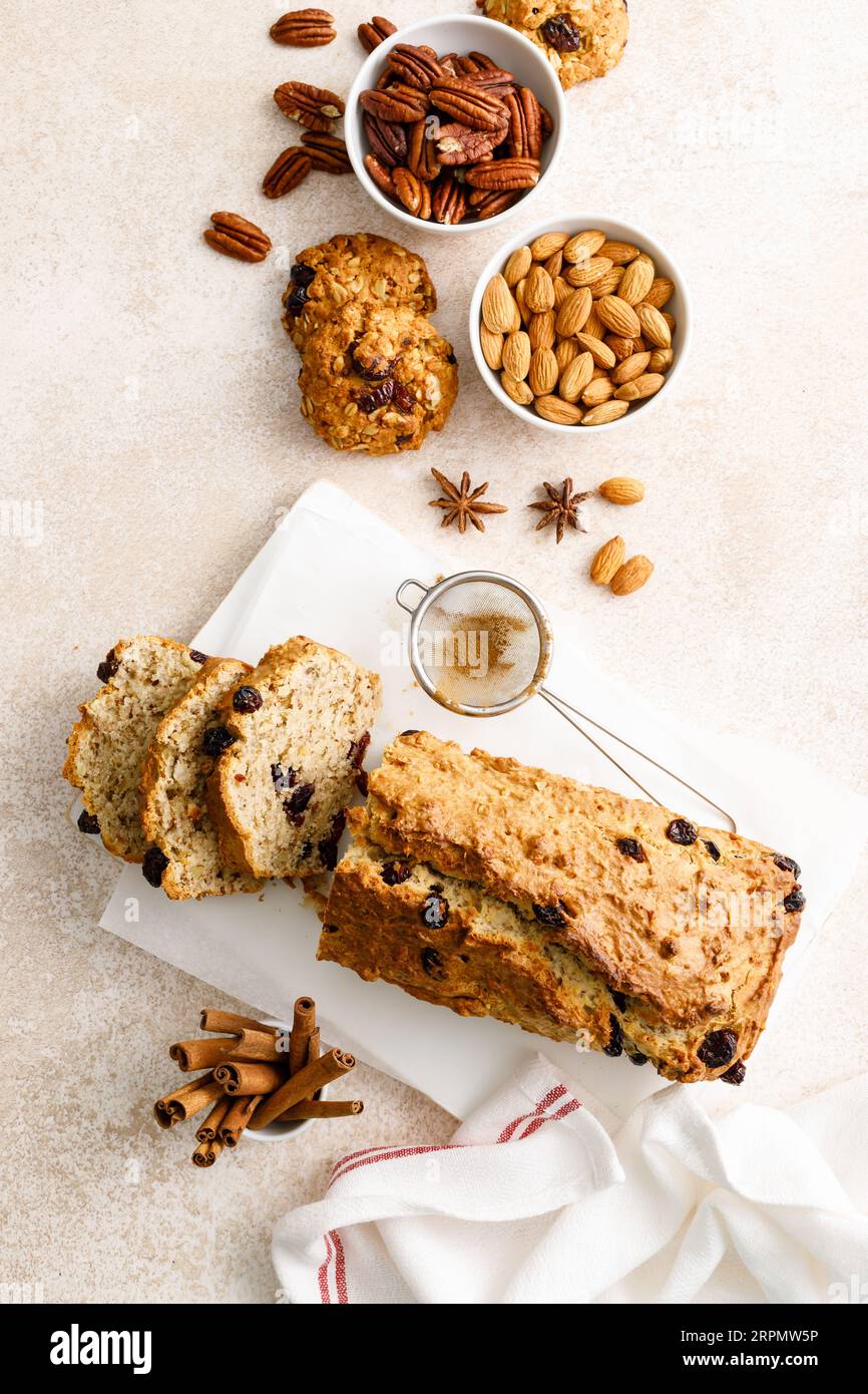 Torta alla frutta con mirtilli rossi, mandorle e noci pecan tagliate su un tagliere di legno Foto Stock