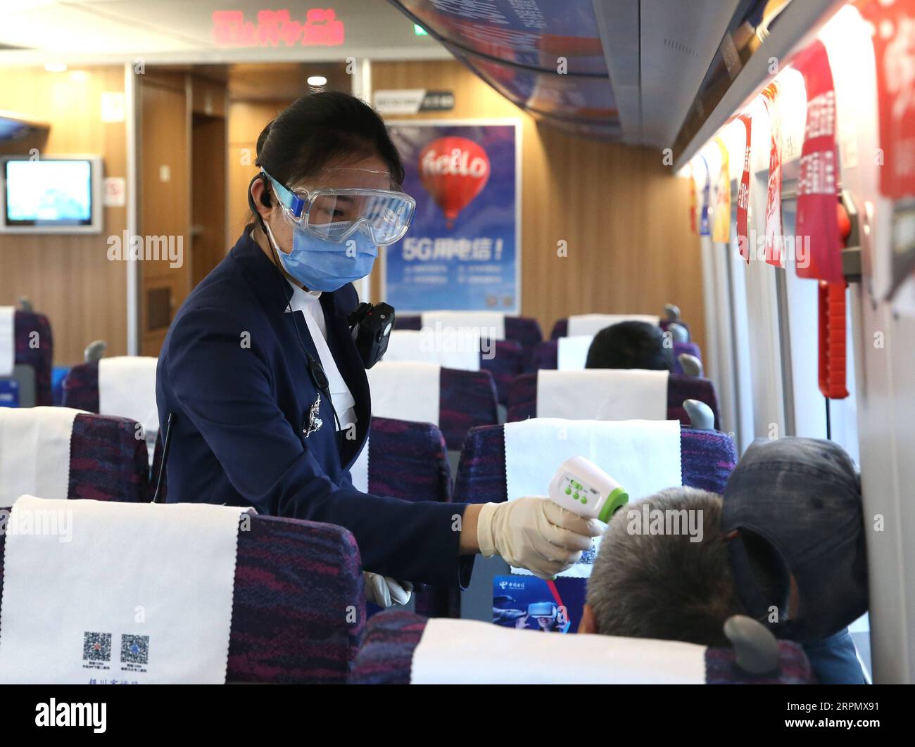 200218 -- YINCHUAN, 18 febbraio 2020 -- Una hostess controlla la temperatura corporea di un passeggero sul treno C8201 da Yinchuan a Zhongwei, nella regione autonoma Ningxia Hui della Cina nord-occidentale, 18 febbraio 2020. Il dipartimento dei trasporti locali ha introdotto una serie di misure per garantire la sicurezza dei passeggeri durante la lotta contro la nuova epidemia di coronavirus. CHINA-NINGXIA-YINCHUAN-NOVEL CORONAVIRUS-TRANSPORT CN JIAXHAOCHENG PUBLICATIONXNOTXINXCHN Foto Stock