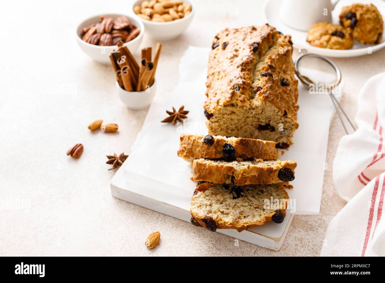Torta alla frutta con mirtilli rossi, mandorle e noci pecan tagliate su un tagliere di legno Foto Stock