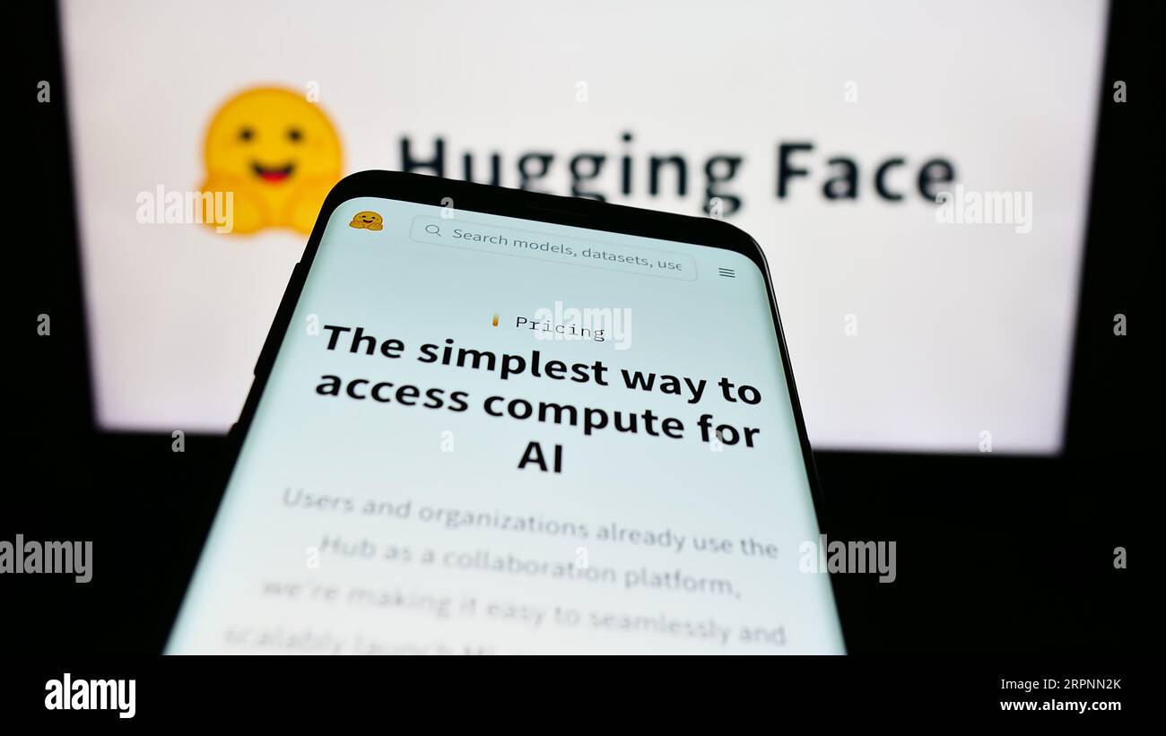 Telefono cellulare con sito web della società di intelligenza artificiale Hugging Face Inc. Sullo schermo davanti al logo. Mettere a fuoco in alto a sinistra sul display del telefono. Foto Stock