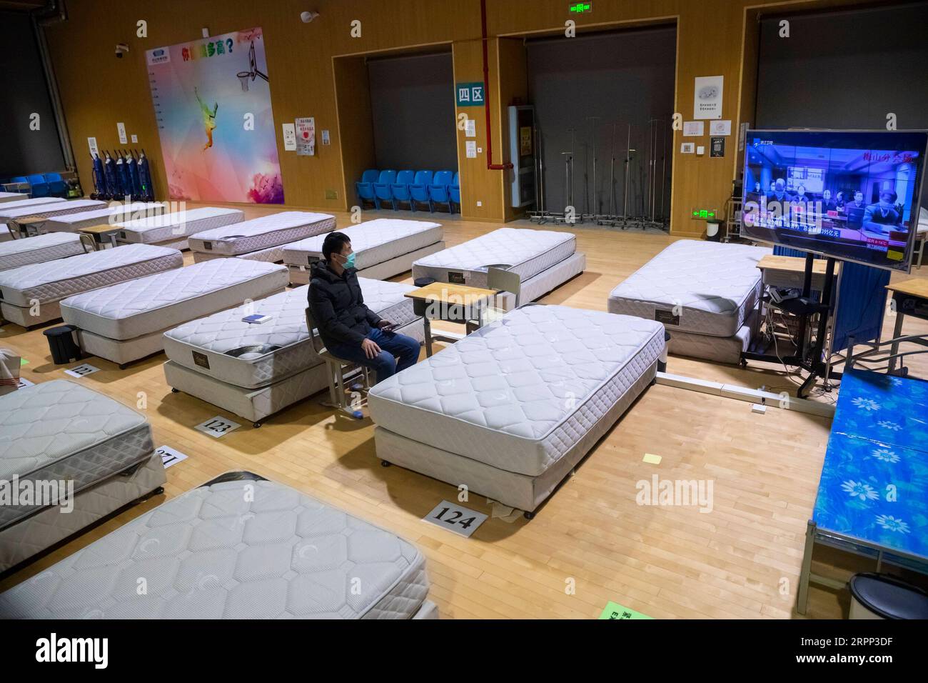 200310 -- WUHAN, 10 marzo 2020 -- Un paziente di COVID-19 guarda la TV in un ospedale temporaneo convertito dal ginnasio di Hongshan a Wuhan, nella provincia di Hubei della Cina centrale, 9 marzo 2020. Wuhan, l'epicentro della nuova epidemia di coronavirus nella provincia di Hubei nella Cina centrale, dovrebbe sospendere gli ultimi due ospedali temporanei rimasti in funzione martedì, poiché il numero di pazienti COVID-19 ha continuato a diminuire in città. CHINA-HUBEI-WUHAN-TEMPORARY HOSPITAL-CLOSINGCN SHENXBOHAN PUBLICATIONXNOTXINXCHN Foto Stock