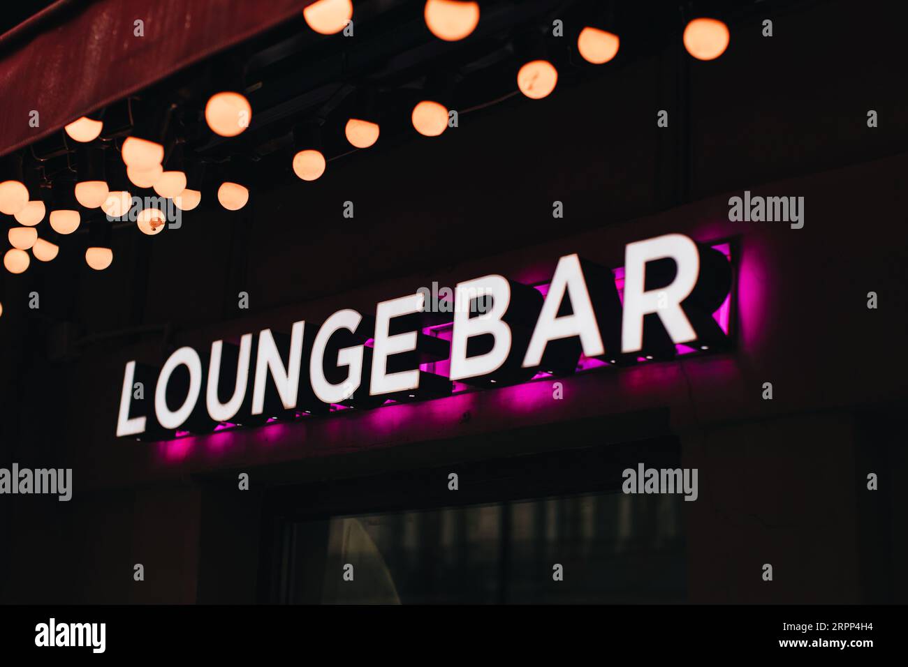 Insegna al neon su sfondo nero, la lounge bar con iscrizione con luce rosa Foto Stock