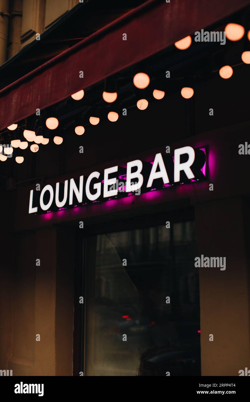 Insegna al neon su sfondo nero, la lounge bar con iscrizione con luce rosa. Verticale Foto Stock