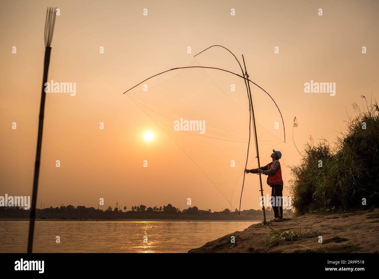 200311 -- VIENTIANE, 11 marzo 2020 -- Un pescatore laotiano lancia una rete da pesca accanto al fiume Mekong vicino a Vientiane, Laos, il 10 marzo 2020. Foto di Kaikeo Saiyasane/Xinhua LAOS-VIENTIANE-MEKONG RIVER-FISHERMAN ZhangxJianhua PUBLICATIONxNOTxINxCHN Foto Stock