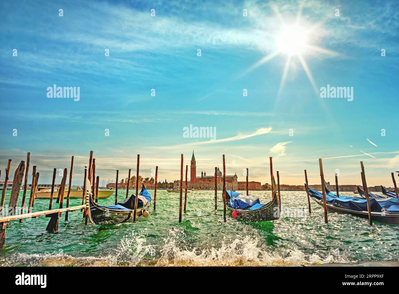 Paesaggio con gondole e vista della chiesa di San Giorgio maggiore sul Canal grande in una giornata di sole. Venezia, Italia Foto Stock