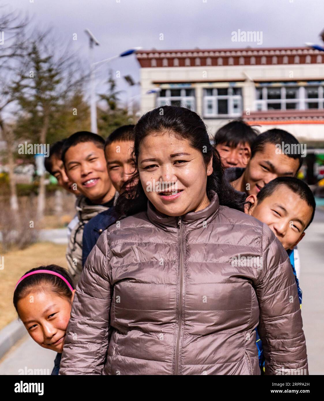 200314 -- LHASA, 14 marzo 2020 -- Pandor posa per una foto di gruppo con i bambini in una casa per bambini a Lhasa, nella regione autonoma Tibet del sud-ovest della Cina, 11 marzo 2020. Pandor è nato a Shigatse, nella regione autonoma del Tibet della Cina sud-occidentale, una città vicino al confine con Nepal, Bhutan e India. È una madre orgogliosa di 22 figli, anche se la bambina di 37 anni non è mai stata incinta o sposata. Sei anni fa, Pandor si trasferì nella capitale regionale, Lhasa, dove trovò un lavoro in una casa per bambini per neonati fino agli studenti del college. La casa era alla ricerca di donne per gestire le unità familiari Foto Stock