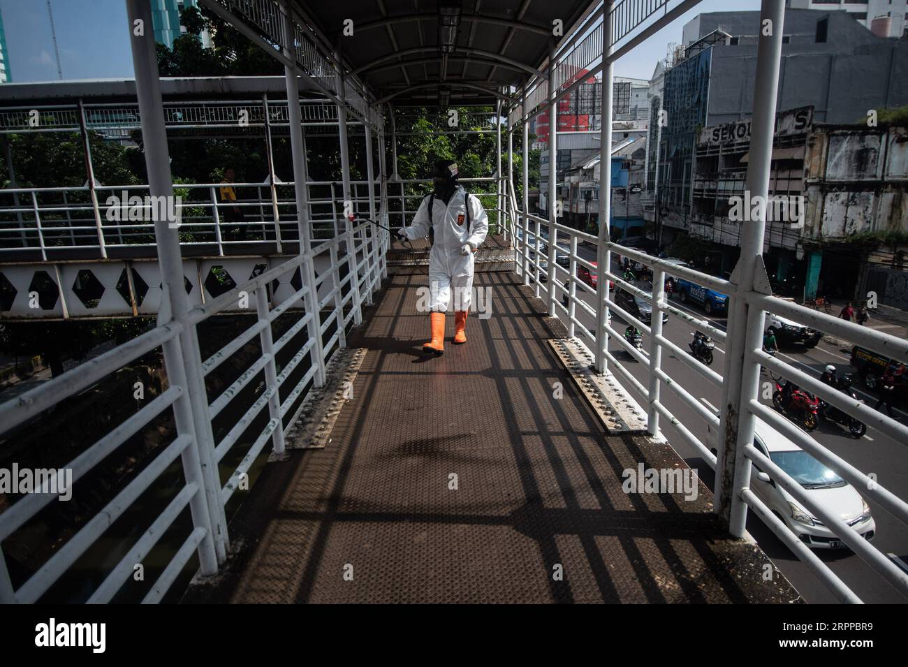 200315 -- GIACARTA, 15 marzo 2020 -- Un volontario spruzza disinfettante su un ponte pedonale a Giacarta, Indonesia, 15 marzo 2020. Varie organizzazioni sociali hanno partecipato all'irrorazione di disinfettanti nelle aree pubbliche di Giacarta. Secondo il portavoce del governo indonesiano Achmad Yurianto, il numero di casi è salito a 96, l'Indonesia ha riportato cinque morti per l'infezione da virus COVID-19. INDONESIA-JAKARTA-COVID-19-DISINFETTANTE VerixSanovri PUBLICATIONxNOTxINxCHN Foto Stock