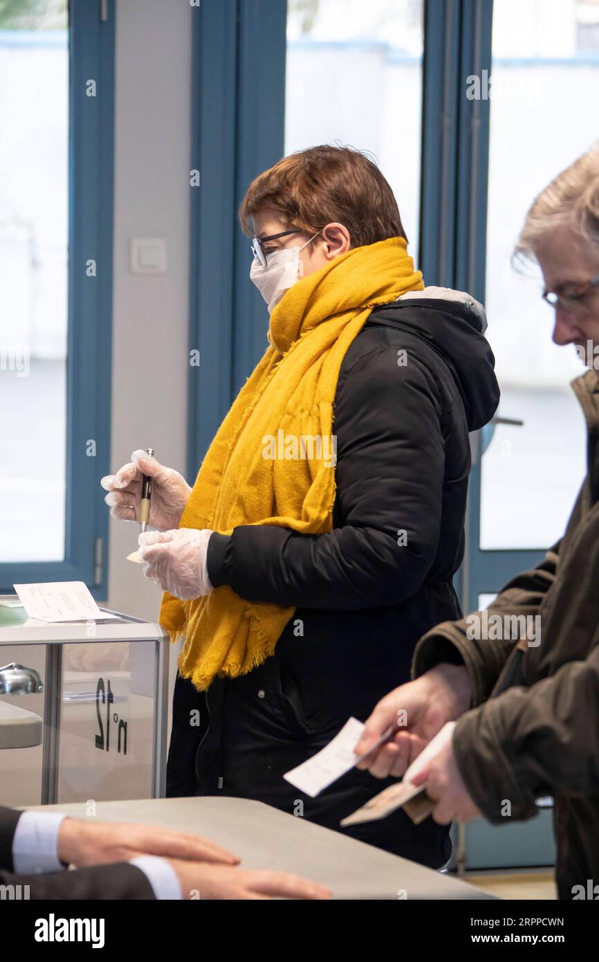 200315 -- LILLE, 15 marzo 2020 Xinhua -- Una donna che indossa maschera e guanti è vista in un seggio elettorale a Lille, nel nord della Francia, 15 marzo 2020. I seggi elettorali sono aperti in tutta la Francia domenica per il primo turno di elezioni comunali dopo che sono state recentemente imposte misure aggiuntive per limitare la diffusione del coronavirus. Le stazioni devono seguire le linee guida sanitarie raccomandate dal governo e dagli esperti sanitari, hanno riferito i media francesi, compresa la pulizia regolare di maniglie delle porte, tavoli e cabine di voto. Altre misure includono evitare le code, applicare una distanza di sicurezza migliore Foto Stock