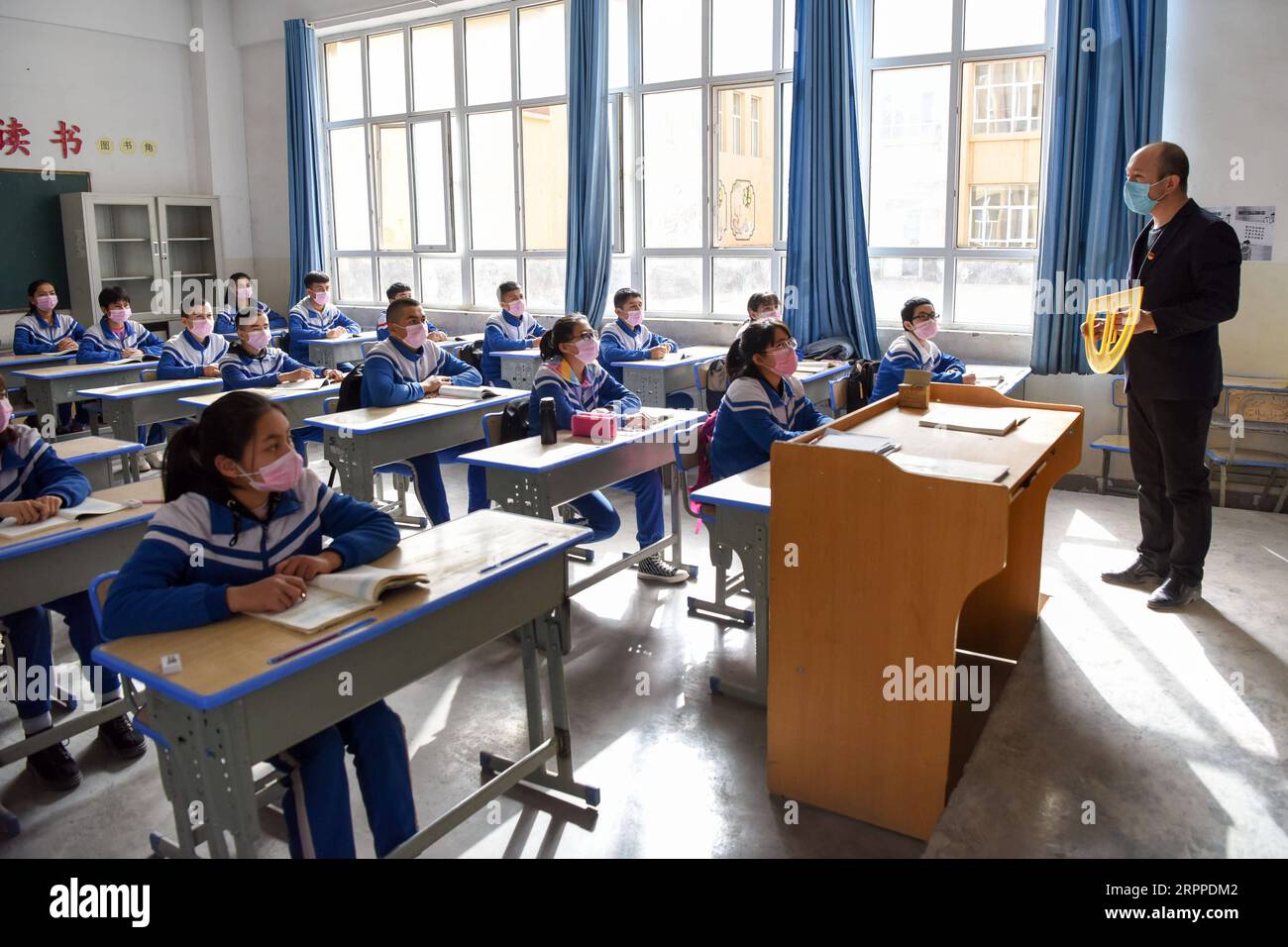 200316 -- KASHGAR, 16 marzo 2020 -- i giovani tre studenti prendono una lezione di matematica alla No. 8 Middle School nella prefettura di Kashgar, regione autonoma di Xinjiang Uygur della Cina nord-occidentale, 16 marzo 2020. Per la studentessa delle scuole superiori della regione autonoma Xinjiang Uygur della Cina nord-occidentale, le lezioni del lunedì sono diverse da quelle che ha preso nelle ultime due settimane: Sono finalmente passate da online a offline. Il lunedì segna il primo giorno di scuola offline del nuovo semestre per gli studenti nei loro ultimi anni di scuole superiori e medie e scuole professionali nello Xinjiang, Ontario Foto Stock