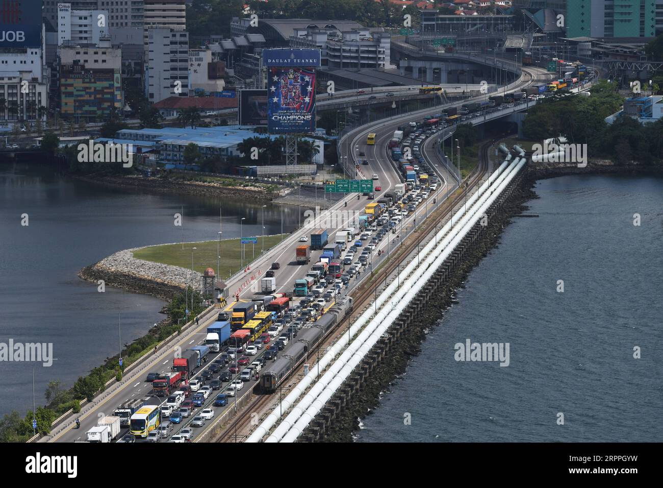 200318 -- PECHINO, 18 marzo 2020 -- i veicoli in viaggio per Singapore dalla Malesia causano un inceppamento sulla Singapore-Johor Causeway il 17 marzo 2020. La Malaysia sta introducendo misure restrittive globali, tra cui la chiusura di negozi e scuole e l'imposizione di divieti di viaggio, nel tentativo di contenere l'epidemia di COVID-19, il primo ministro Muhyiddin Yassin ha annunciato lunedì. Le misure entreranno in vigore dal 18 marzo al 31 marzo, ha detto Muhyiddin. Foto di /Xinhua XINHUA FOTO DEL GIORNO ThenxChihxWey PUBLICATIONxNOTxINxCHN Foto Stock