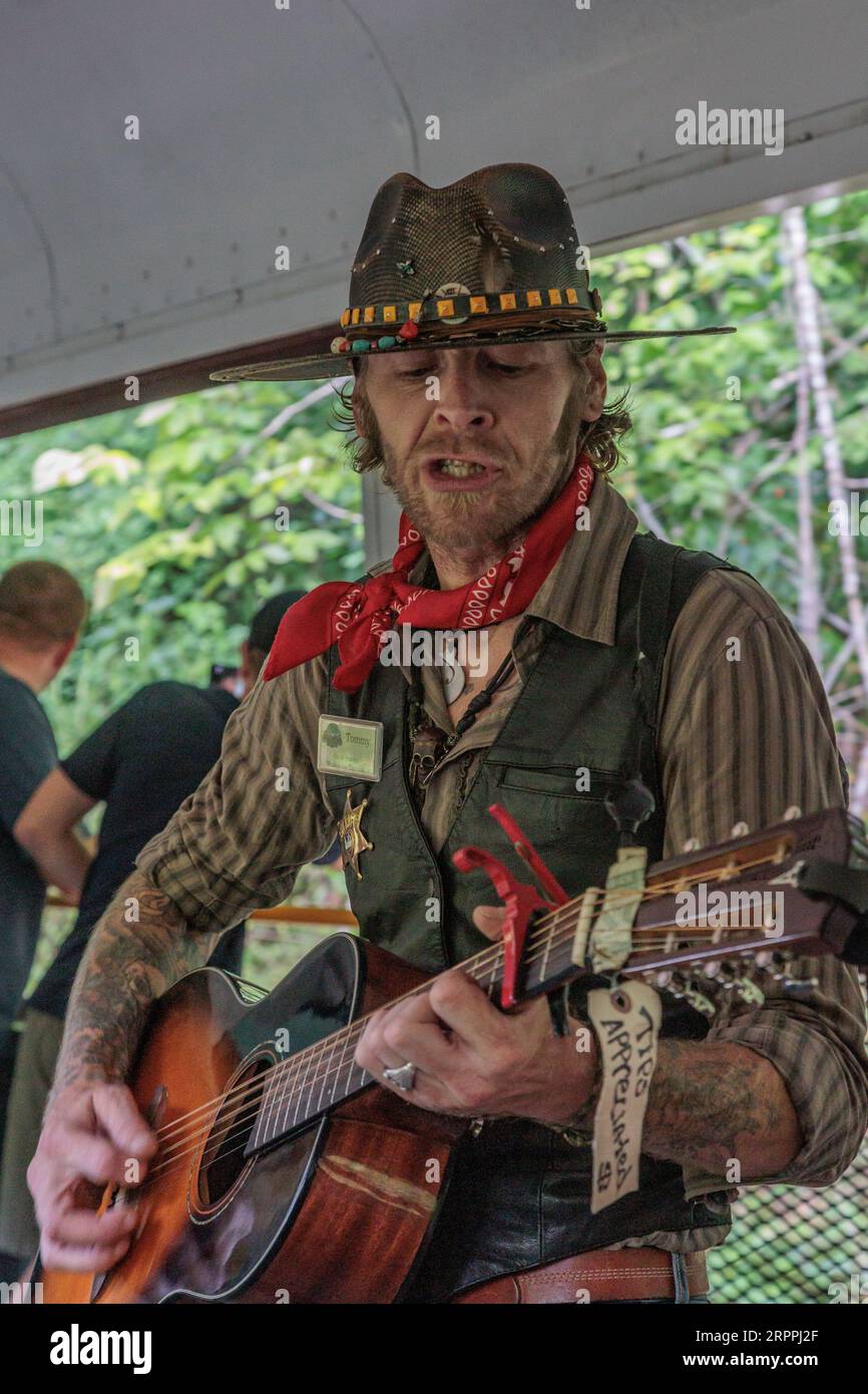 Cantante e intrattenitore che cantano canzoni ai passeggeri per consigli sull'escursione della Great Smoky Mountains Railroad da Bryson City, North Carolina Foto Stock