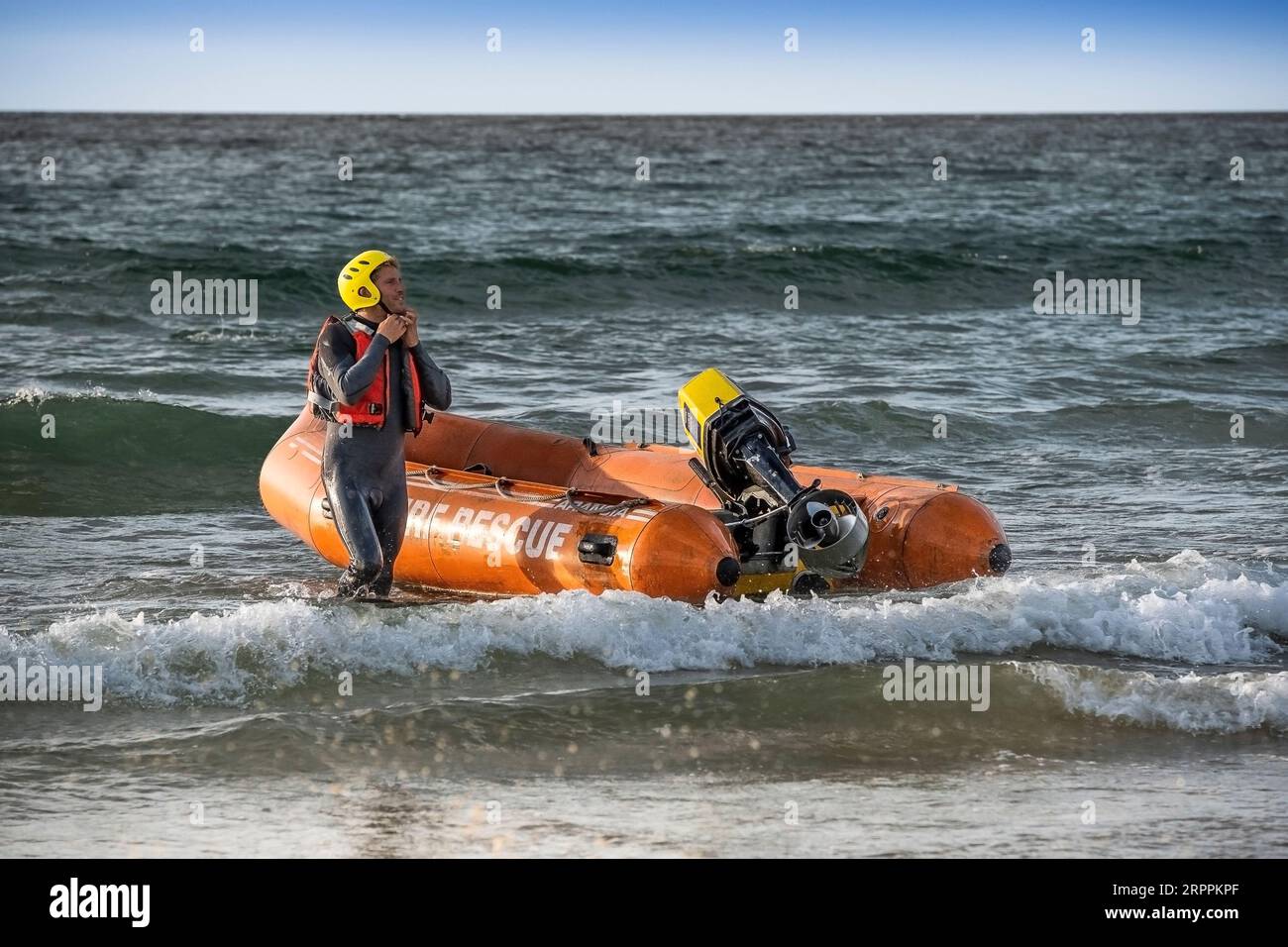 I membri del Newquay Surf Life Saving Club si preparano a lanciare un'imbarcazione di soccorso costiera di classe Arancia per una sessione di addestramento a Fistral a Newquay in C. Foto Stock