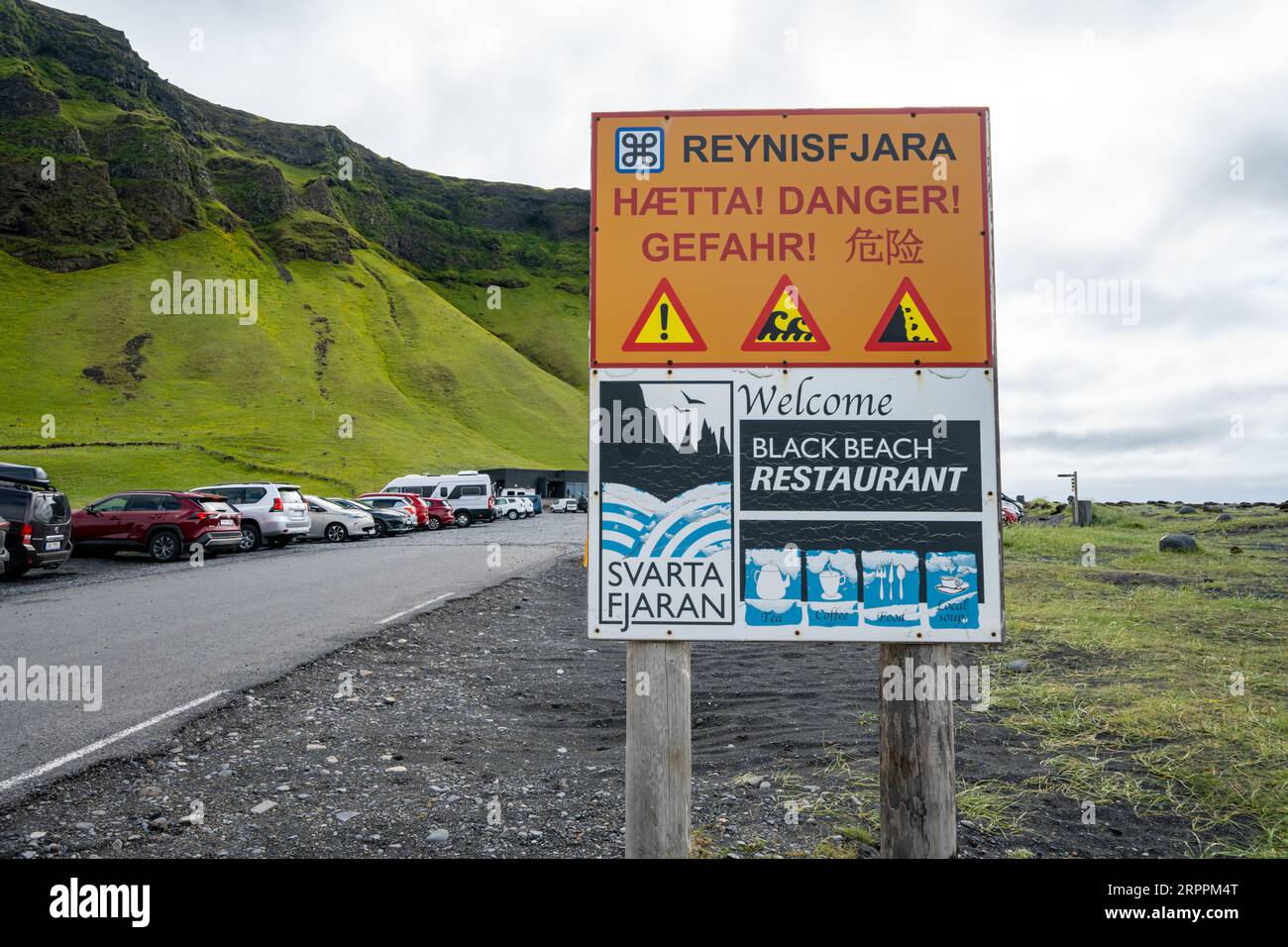 Vik, Islanda - 8 luglio 2023: Cartello che ricorda ai turisti e ai visitatori i pericoli delle onde di sneaker a Reynisfjara Black Sand Beach. Foto Stock