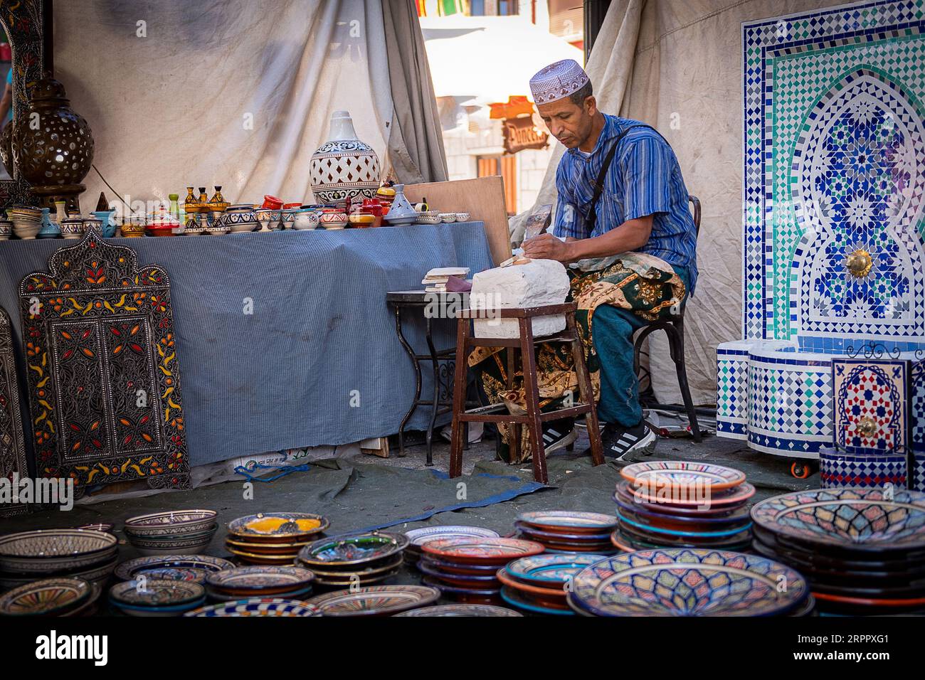 Laboratorio di artigianato marocchino, insieme a un lavoratore sullo sfondo, circondato dai loro prodotti. Fotografia scattata il 2 settembre 2023 nella città di Av Foto Stock