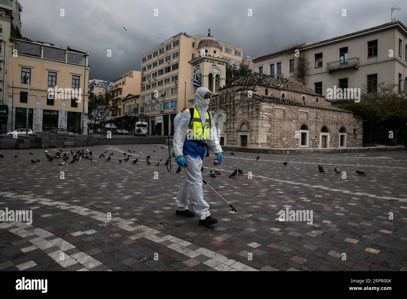 200323 -- ATENE, 23 marzo 2020 -- Un operaio disinfetta una piazza nel centro storico di Atene, Grecia, il 23 marzo 2020. Le strade cittadine in tutta la Grecia sono state deserte quando il governo ha lanciato lunedì un blocco nazionale di 14 giorni nel tentativo di contenere l'ulteriore diffusione della COVID-19. Finora la Grecia ha registrato 17 decessi legati alla COVID-19, rispetto ai 15 segnalati un giorno prima e a 71 nuovi casi confermati, portando il totale a 695. Foto di /Xinhua GRECIA- ATENE-COVID19-LOCKDOWN LEFTERISxPARTSALIS PUBLICATIONxNOTxINxCHN Foto Stock