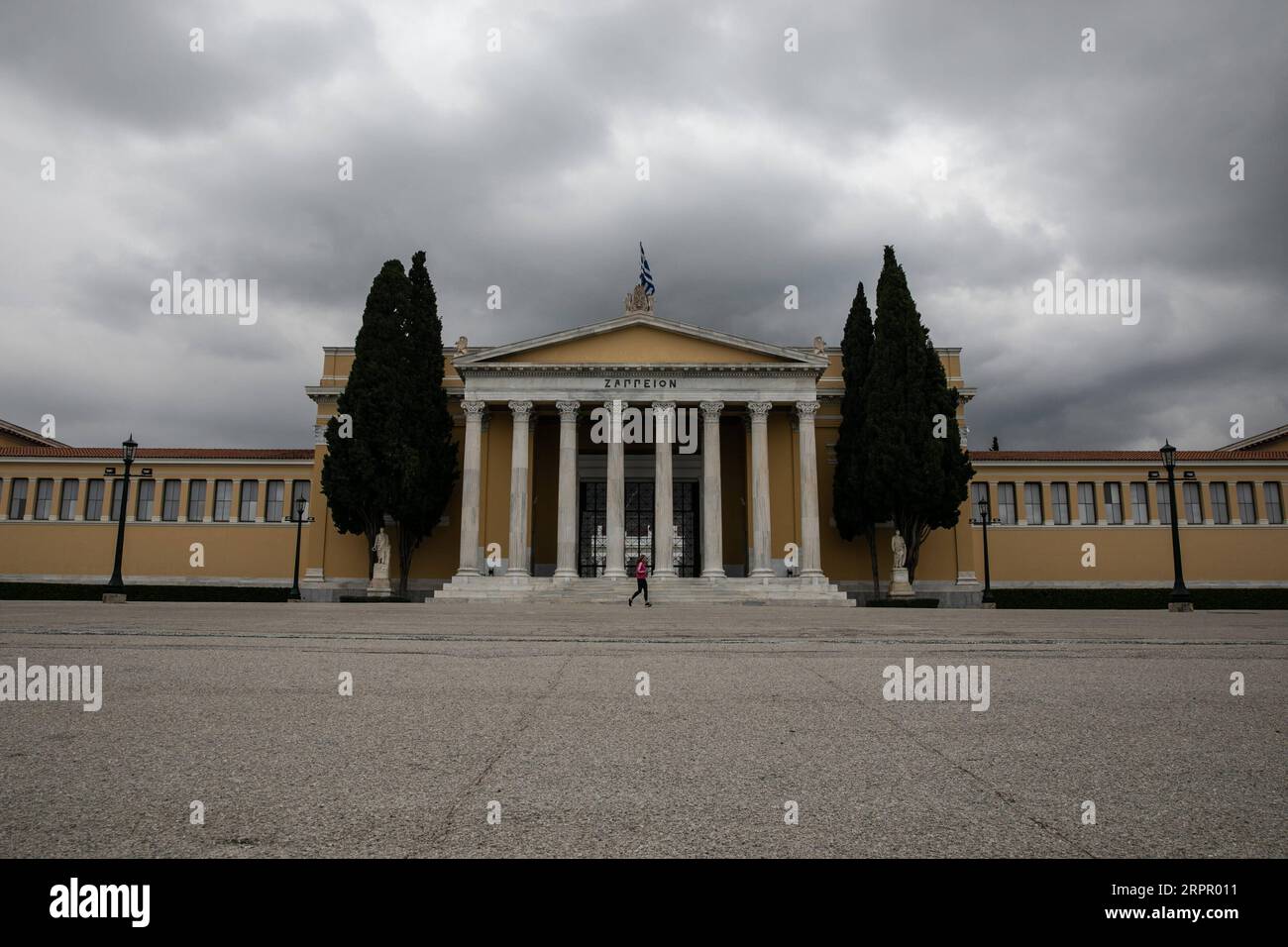 200323 -- ATENE, 23 marzo 2020 -- Una donna corre intorno alla Zappeion Mansion ad Atene, Grecia, il 23 marzo 2020. Le strade cittadine in tutta la Grecia sono state deserte quando il governo ha lanciato lunedì un blocco nazionale di 14 giorni nel tentativo di contenere l'ulteriore diffusione della COVID-19. Finora la Grecia ha registrato 17 decessi legati alla COVID-19, rispetto ai 15 segnalati un giorno prima e a 71 nuovi casi confermati, portando il totale a 695. Foto di /Xinhua GRECIA- ATENE-COVID19-LOCKDOWN LEFTERISxPARTSALIS PUBLICATIONxNOTxINxCHN Foto Stock