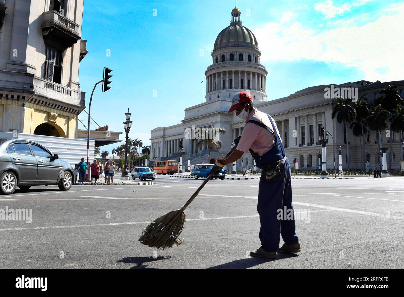 200324 -- L'AVANA, 24 marzo 2020 Xinhua -- Un uomo che indossa una maschera spazza via a l'Avana, Cuba, 23 marzo 2020. Il presidente cubano Miguel Diaz Canel lunedì ha esortato le istituzioni statali, i settori privati e le persone ad aumentare il controllo e la disciplina nel tentativo di contenere l'epidemia di COVID-19. Foto di Joaquin Hernandez/Xinhua CUBA-HAVANA-COVID-19 PUBLICATIONxNOTxINxCHN Foto Stock