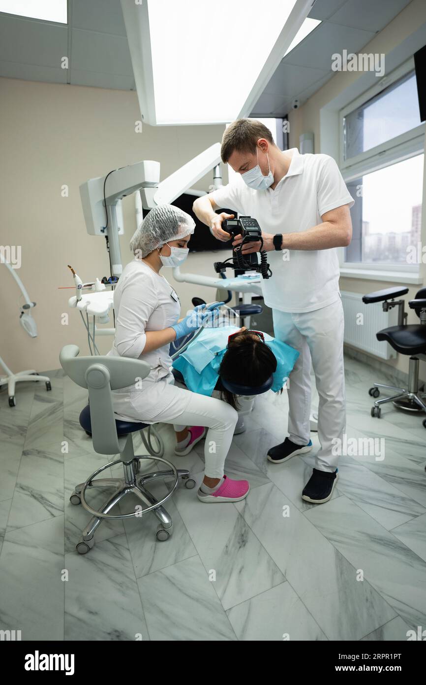 Il dentista utilizza una fotocamera per esaminare un paziente. Foto Stock