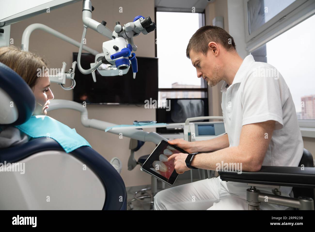 Il dentista comunica con il paziente nello studio dentistico. Foto Stock