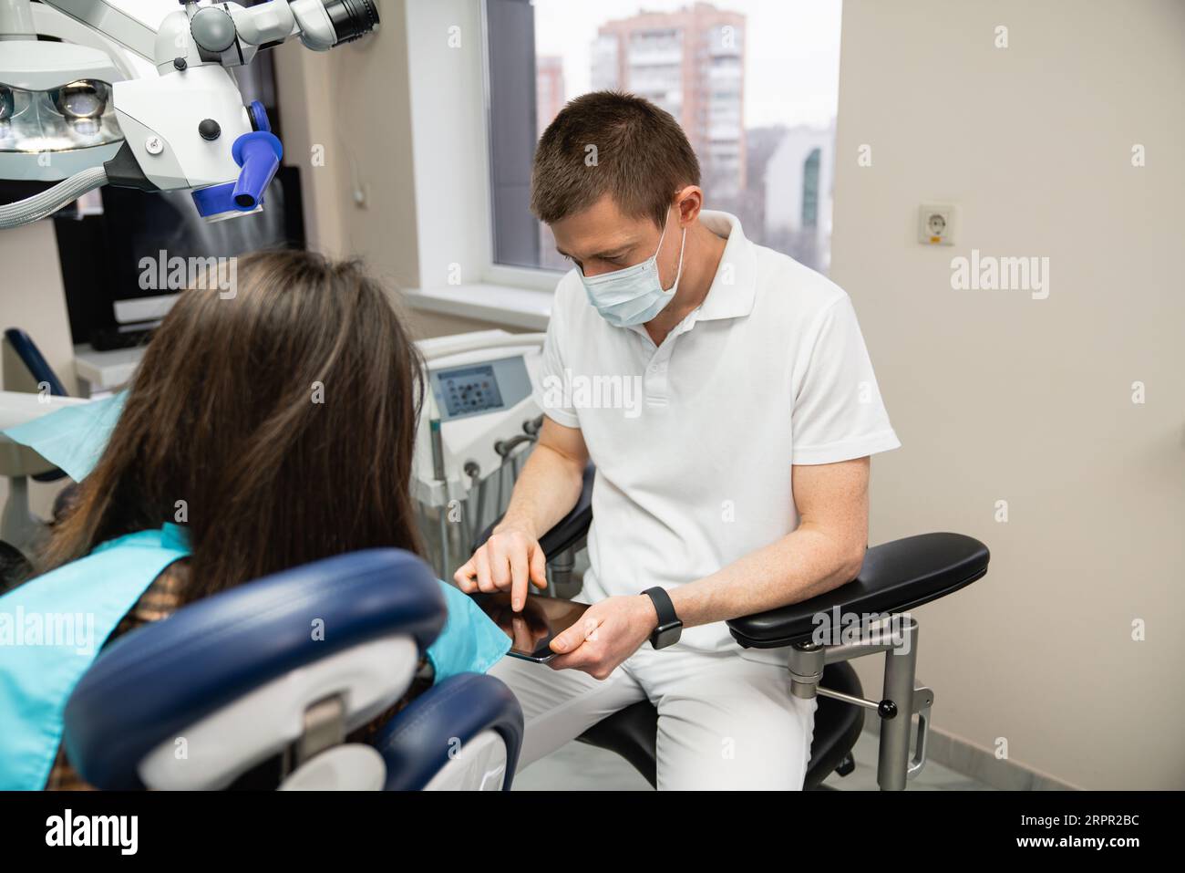 Il dentista comunica con il paziente nello studio dentistico. Foto Stock
