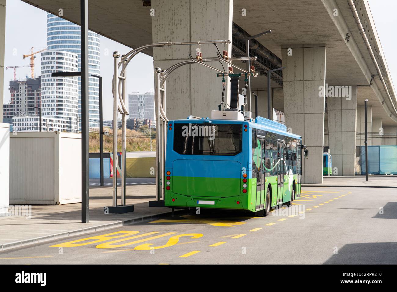 Il bus elettrico a una fermata viene caricato dal pantografo. Mobilità pulita. Foto Stock