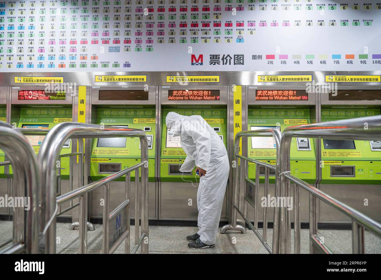 200328 -- WUHAN, 28 marzo 2020 -- Un passeggero acquista un biglietto da un distributore automatico di biglietti presso la stazione della metropolitana di Wuchang Railway Station a Wuhan, nella provincia di Hubei della Cina centrale, 28 marzo 2020. Sei linee della metropolitana a Wuhan hanno ripreso a funzionare a partire da sabato, un nuovo segno che la vita sta gradualmente tornando alla normalità nella città più colpita. I passeggeri sono tenuti a scansionare il codice QR per la registrazione del vero nome e a effettuare controlli della temperatura prima di prendere la metropolitana. Ogni treno è dotato di un membro dell'equipaggio di sicurezza del treno per aiutare a guidare e servire i passeggeri. CHINA-HUBEI-WUHAN-METRO-OPERATION RE Foto Stock