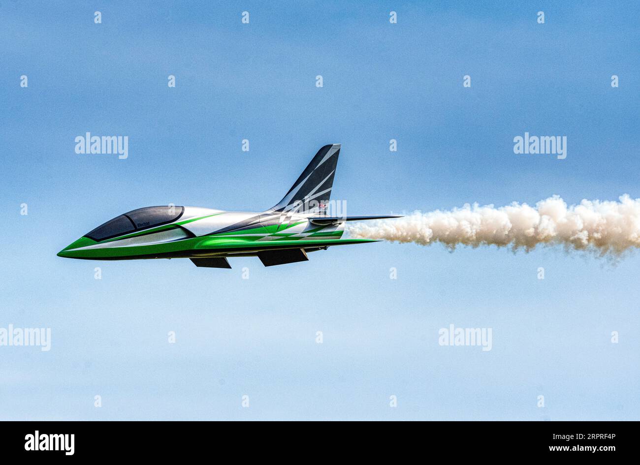Un modello di jet radiocomandato mette in fuga una pista di fumo in un sorvolo al Popham Airfield, esposizione di modellini, Popham, Hampshire, Regno Unito Foto Stock
