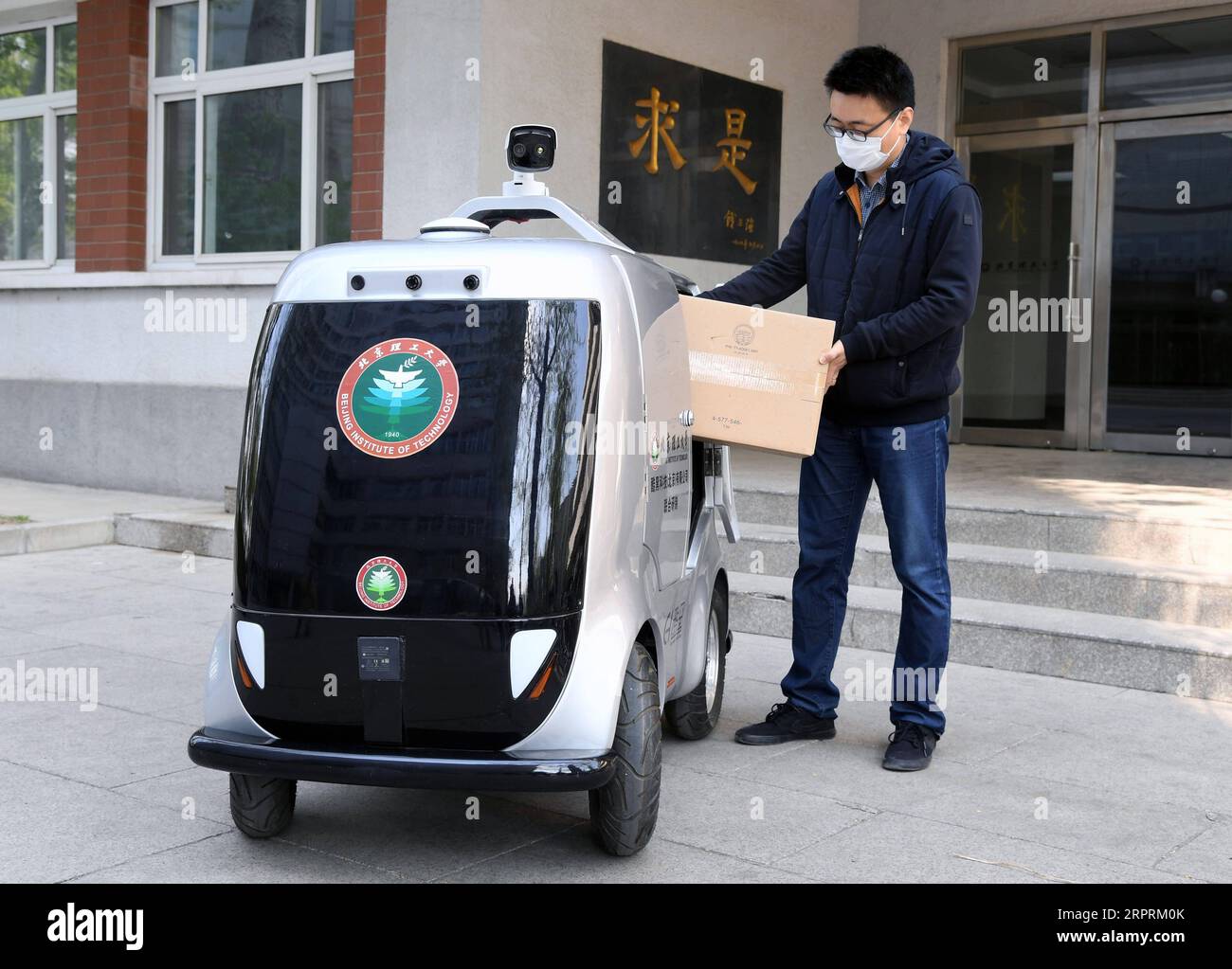 200406 -- PECHINO, 6 aprile 2020 -- Un membro del personale mette le merci nell'auto di consegna senza equipaggio 5G dell'Istituto tecnologico di Pechino, capitale della Cina, 6 aprile 2020. Al Beijing Institute of Technology è stata messa in uso un'auto di consegna senza equipaggio 5G, in grado di misurare la temperatura delle persone che entrano nel campus, riconoscere le informazioni facciali e condurre consegne senza contatto. CHINA-BEIJING-CAMPUS-CONSEGNA SENZA EQUIPAGGIO CN RENXCHAO PUBLICATIONXNOTXINXCHN Foto Stock