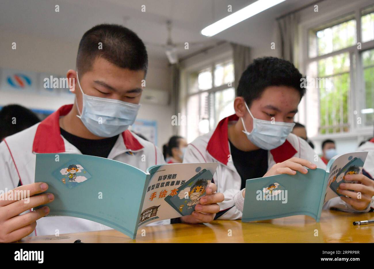 200407 -- XI AN, 7 aprile 2020 -- gli studenti leggono un opuscolo realizzato dagli insegnanti sulla prevenzione epidemica del nuovo coronavirus nella scuola media Huizhi a Xi An, provincia dello Shaanxi della Cina nord-occidentale, 7 aprile 2020. Gli studenti nell'ultimo anno delle scuole medie o professionali sono tornati a scuola martedì in Shaanxi. CHINA-SHAANXI-XI AN-JUNIOR HIGH SCHOOL STUDENTS-RETURN TO SCHOOL CN LIUXXIAO PUBLICATIONXNOTXINXCHN Foto Stock
