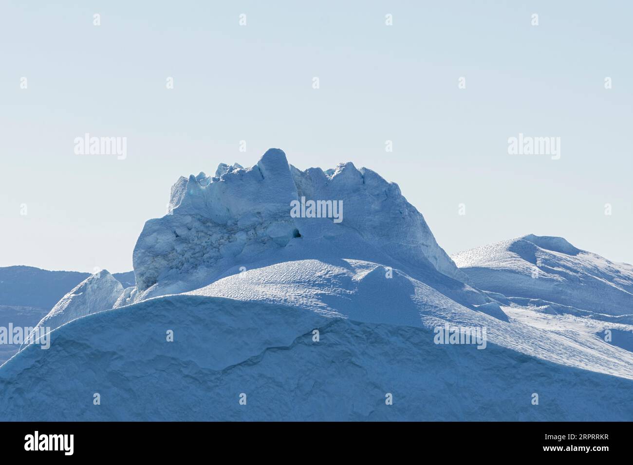 Primo piano di un imponente iceberg galleggiante sotto il sole artico nel fiordo ghiacciato di Ilulissat, patrimonio dell'umanità dell'UNESCO. Ilulissat, Groenlandia Foto Stock