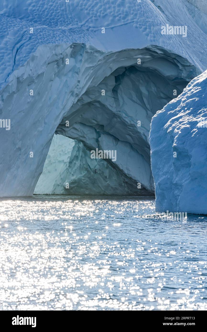 Primo piano di un imponente iceberg galleggiante sotto il sole artico nel fiordo ghiacciato di Ilulissat, patrimonio dell'umanità dell'UNESCO. Ilulissat, Groenlandia, Danimarca Foto Stock