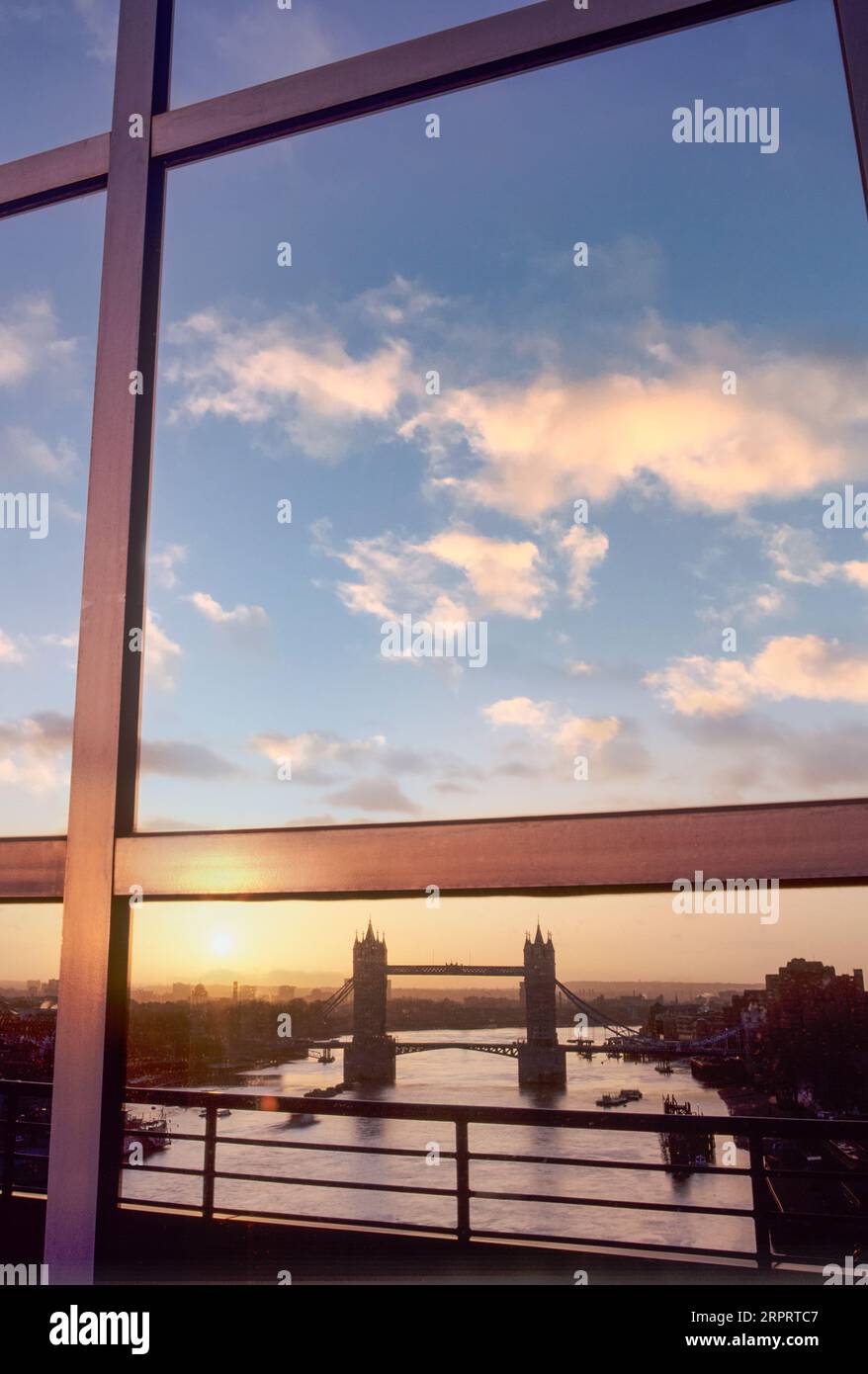 Il Tower Bridge e il fiume Tamigi si riflettono nella moderna città delle banche finanziarie degli uffici delle finestre di vetro all'alba di Londra, Regno Unito Foto Stock