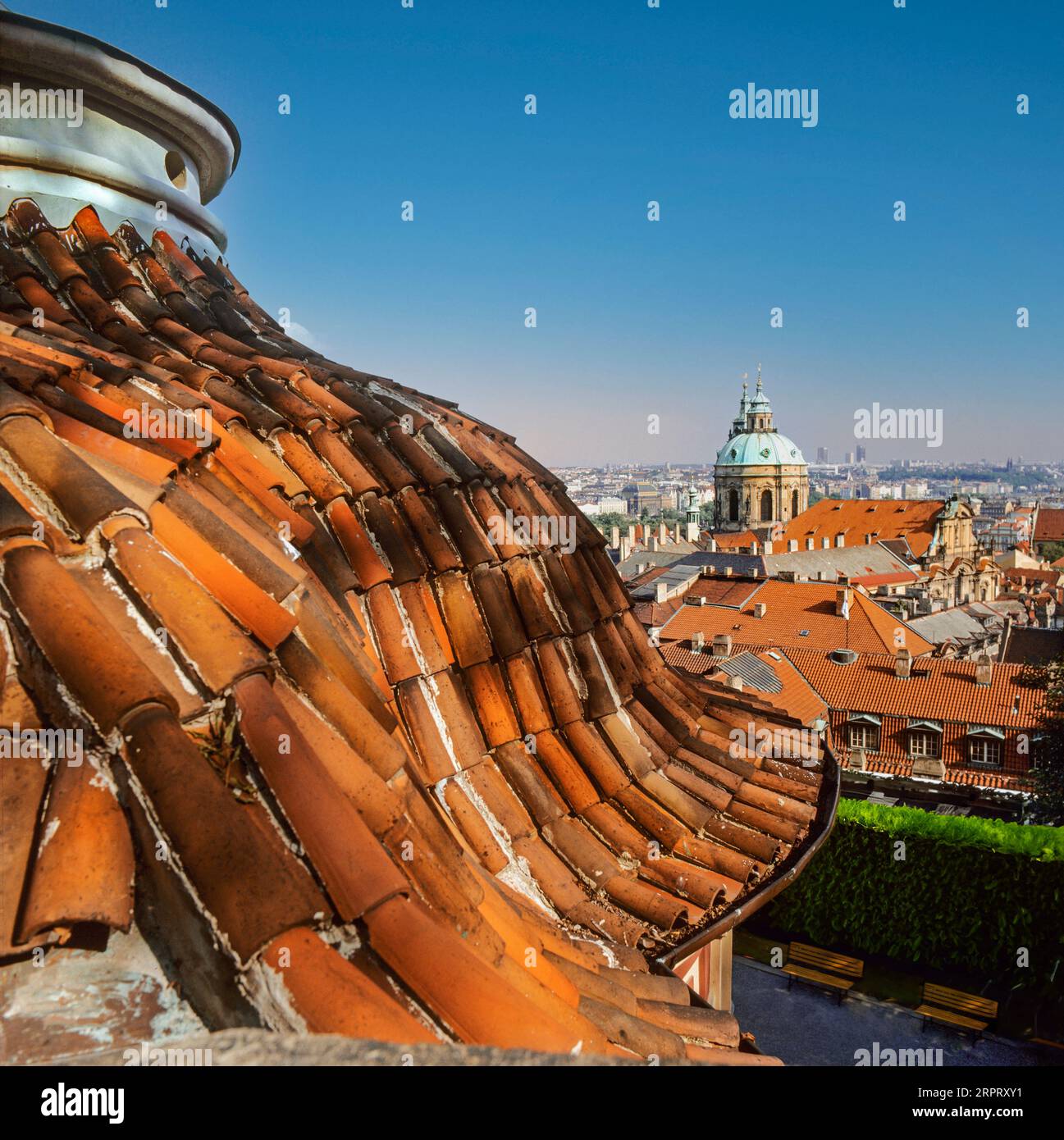 LE TEGOLE DEI TETTI DI PRAGA hanno rovinato il tetto storico in terracotta, incorniciano la vista della chiesa e del centro storico di Praga, Repubblica Ceca Foto Stock