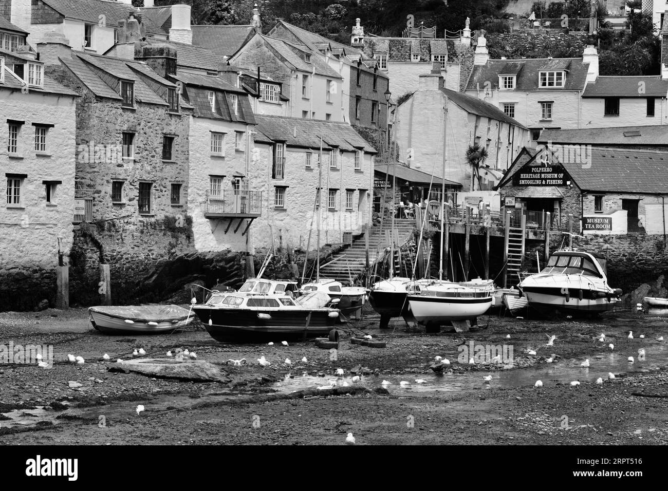 L'immagine in bianco e nero del pittoresco porto di Polperro, con il suo antico patrimonio di contrabbando, è ancora oggi un trafficato porto di pescatori Foto Stock