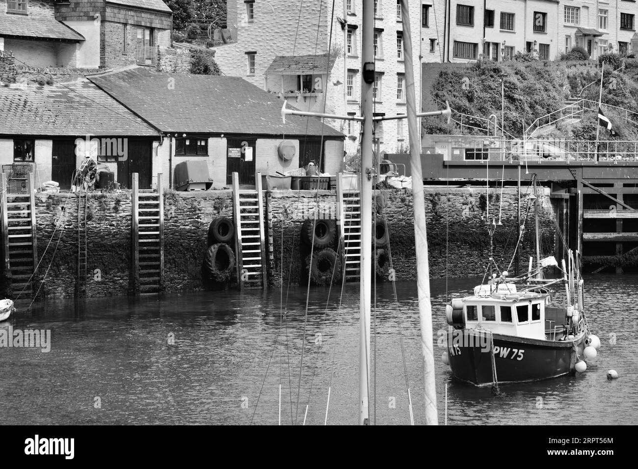 L'immagine in bianco e nero del pittoresco porto di Polperro, con il suo antico patrimonio di contrabbando, è ancora oggi un trafficato porto di pescatori Foto Stock