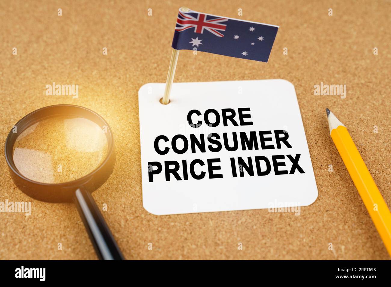Economia e finanza. Sul tavolo ci sono una lente d'ingrandimento, una matita, la bandiera australiana e un foglio di carta con l'iscrizione - core con Foto Stock