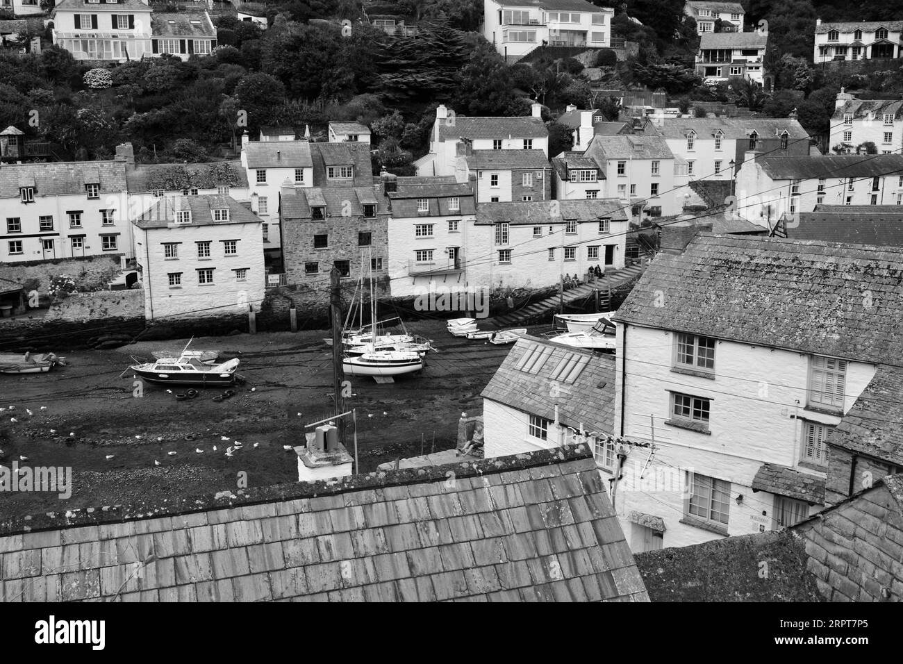L'immagine in bianco e nero del pittoresco porto di Polperro, con il suo antico patrimonio di contrabbando, è ancora oggi un trafficato porto di pescatori Foto Stock