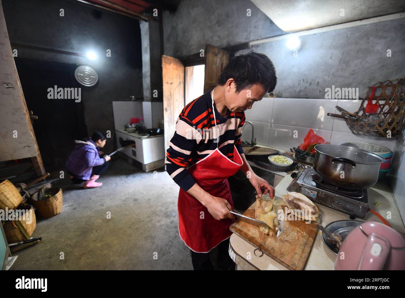 200416 -- RONGAN, 16 aprile 2020 -- Long Gexiong cucina un piatto per i turisti nella cucina della sua casa nel villaggio di Tongbantun di Dongqi Township nella contea di Rongan, nella regione autonoma di Guangxi Zhuang, nella Cina meridionale, 12 aprile 2020. Long Gexiong, 52 anni, lasciò la sua città natale a 24 anni e andò a caccia di posti di lavoro nella città di Liuzhou, nella regione autonoma del Guangxi Zhuang nella Cina meridionale. Dopo due decenni di lavoro all'esterno, tornò finalmente nel suo villaggio natale, nelle montagne profonde. Long abbandonò la scuola nel 1986 a causa della povertà e si guadagnò da vivere piantando alberi di prugne. Tuttavia, colline aride e carenza d'acqua r Foto Stock