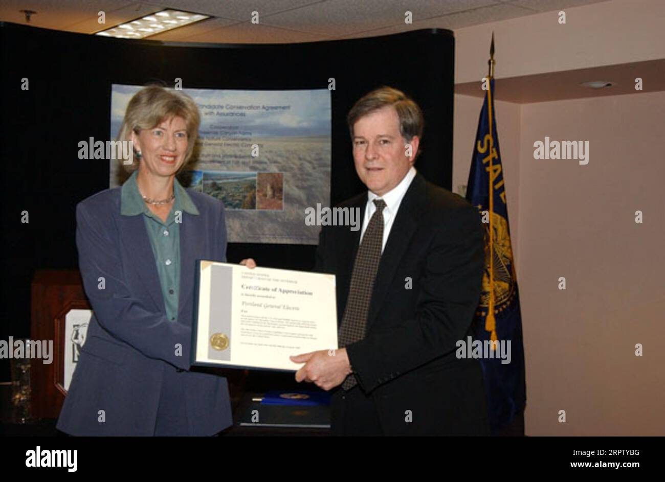 Il segretario Gale Norton presenta il certificato a Stephen Quennoz della Portland General Electric, durante l'evento allo zoo dell'Oregon di Portland, evidenziando l'accordo pubblico-privato per la protezione delle specie animali. Portland General Electric è entrata a far parte dello U.S. Fish and Wildlife Service, dell'Oregon Department of Fish and Wildlife, delle Threemile Canyon Farms, Nature Conservancy Foto Stock