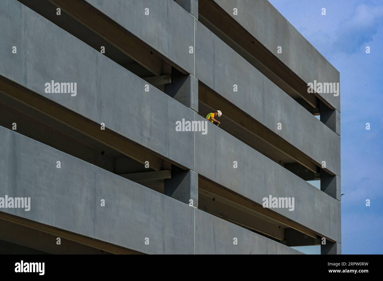 Operaio edile che dipinge un nuovo parcheggio auto, Baltimore Maryland USA Foto Stock