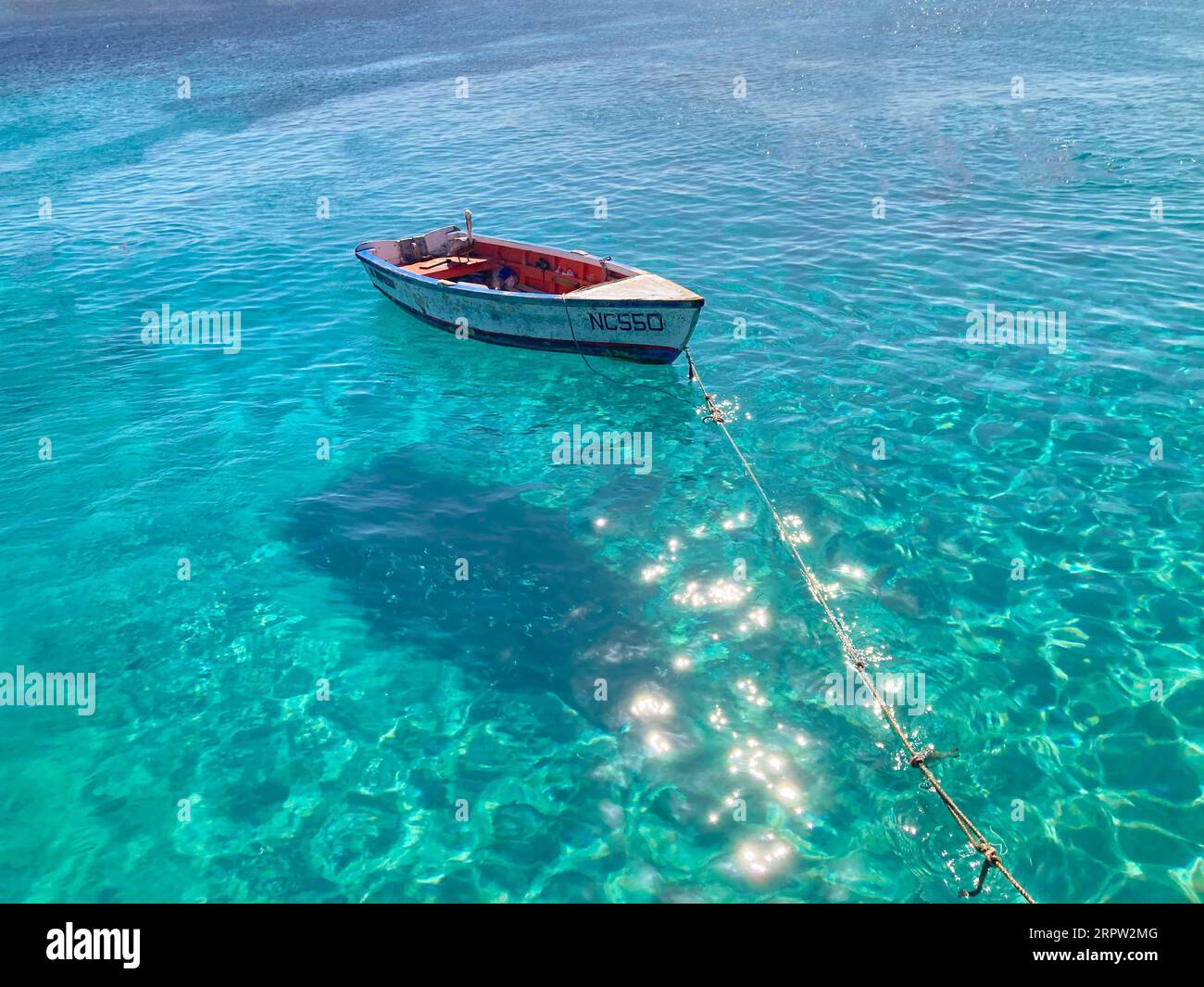 Barca a remi con pellicani che riposa in acque caraibiche molto limpide, Curacao Foto Stock
